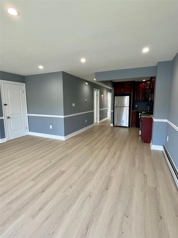 Empty room, Interior, Kitchen, Recessed Lighting, Stainless Steel Appliances, Wood Texture Flooring