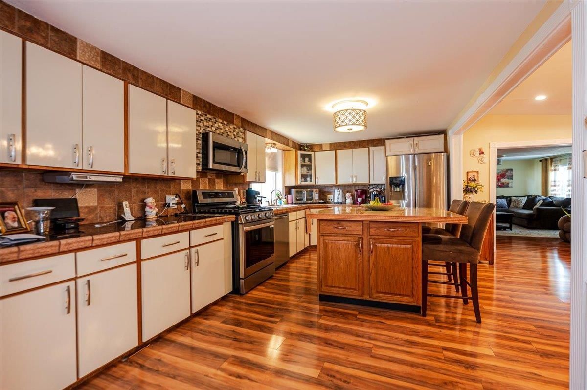 Dining room, Interior, Kitchen, Living room, Recessed Lighting, Stainless Steel Appliances, Tile Countertops, Wood Texture Flooring