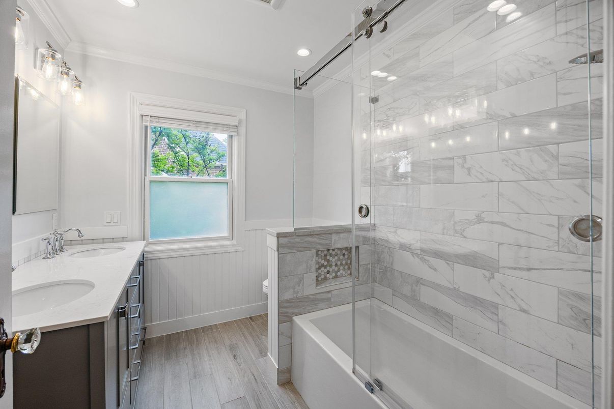 Bathroom, Dual Sink Vanities, Glass Shower, Interior, Marble Walls, Recessed Lighting, Wood Texture Flooring