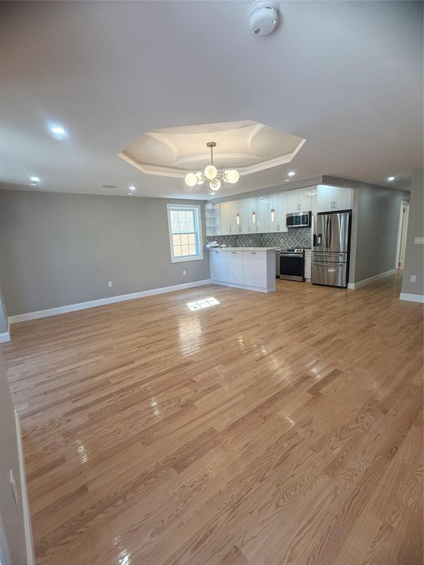 Empty room, Interior, Kitchen, Recessed Lighting, Stainless Steel Appliances, Wood Texture Flooring
