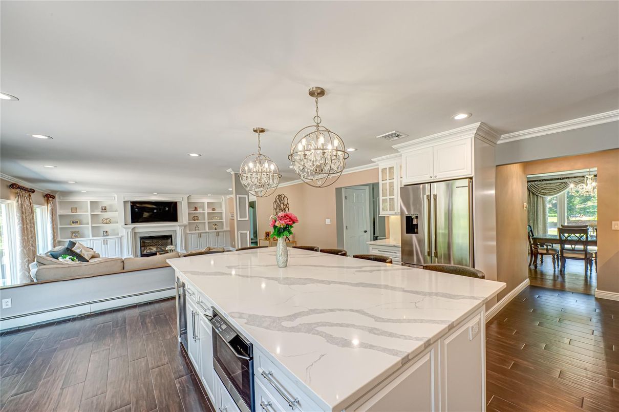 Chandelier, Fireplace, Interior, Kitchen, Living room, Recessed Lighting, Stainless Steel Appliances, Wood Texture Flooring