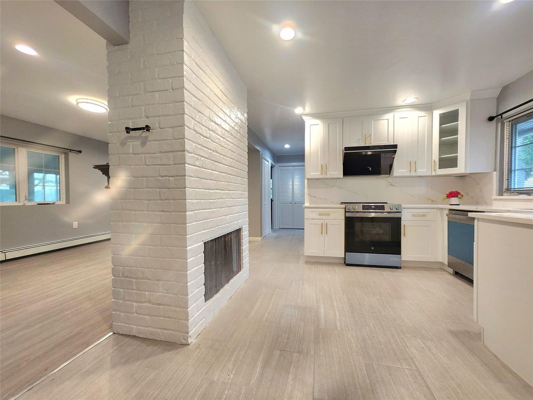 Fireplace, Interior, Kitchen, Marble Walls, Recessed Lighting, Stainless Steel Appliances, Stone Walls, Wood Texture Flooring
