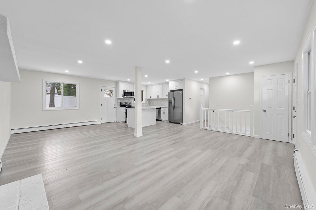 Empty room, Interior, Kitchen, Recessed Lighting, Stainless Steel Appliances, Wood Texture Flooring