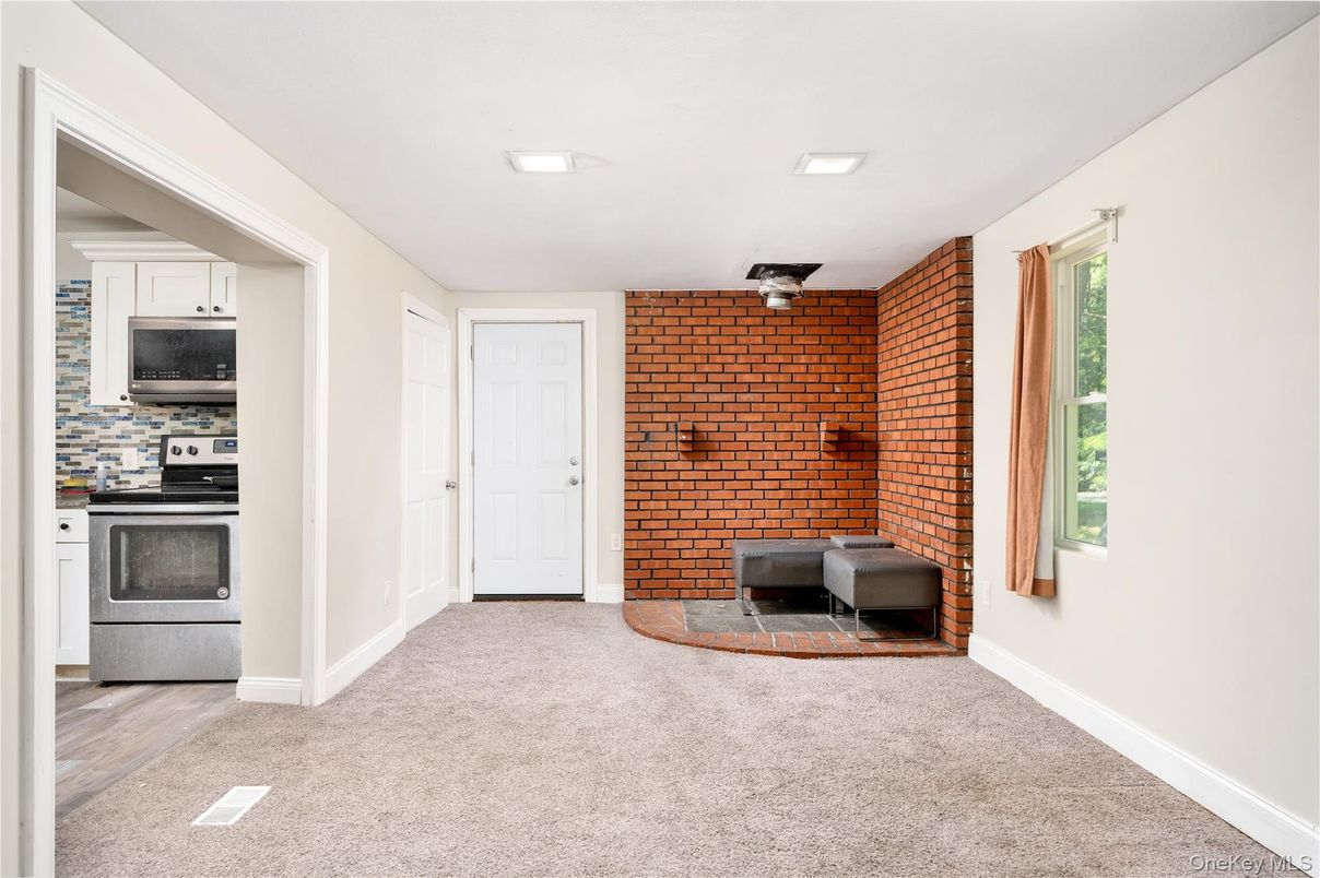 Empty room, Fireplace, Interior, Kitchen, Recessed Lighting, Stainless Steel Appliances, Stone Walls
