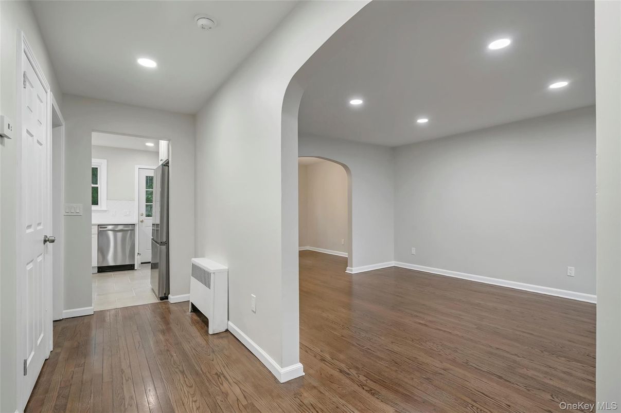 Empty room, Interior, Kitchen, Recessed Lighting, Stainless Steel Appliances, Wood Texture Flooring