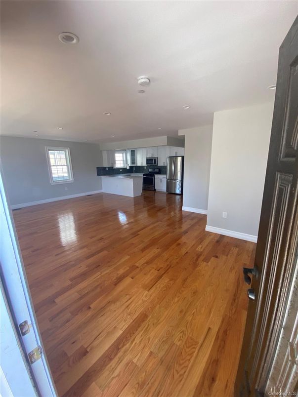 Empty room, Interior, Kitchen, Recessed Lighting, Stainless Steel Appliances, Wood Texture Flooring