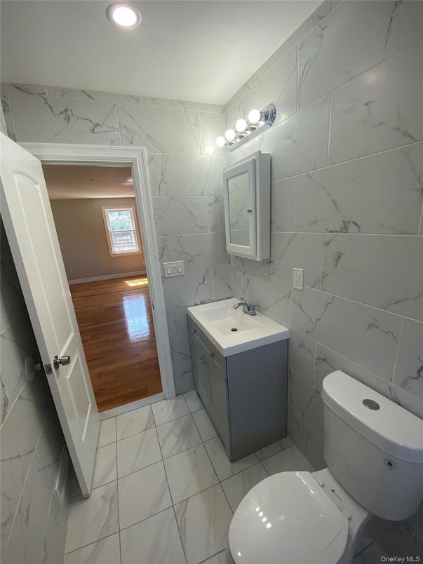 Bathroom, Dual Sink Vanities, Interior, Marble, Marble Walls, Recessed Lighting, Wood Texture Flooring