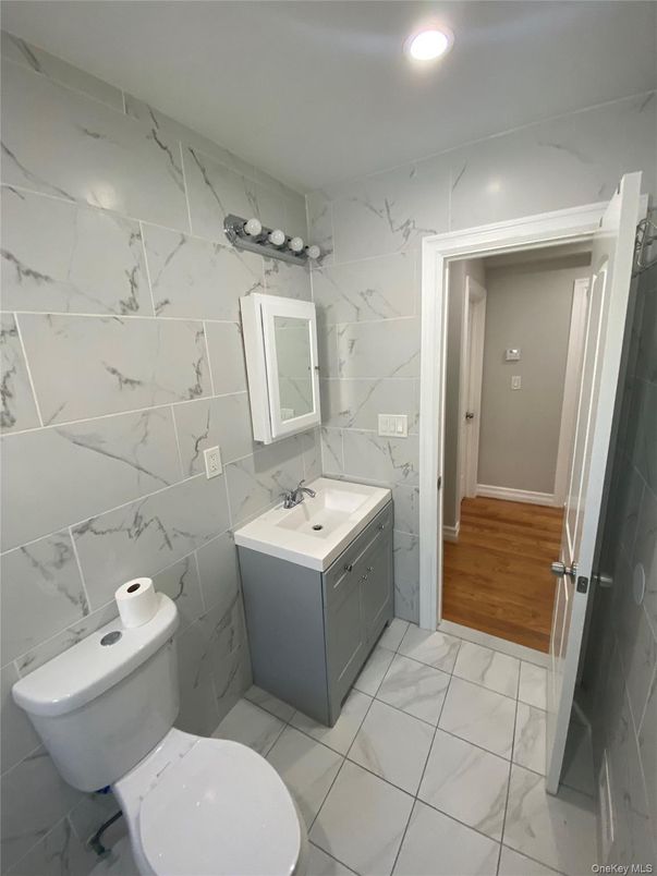 Bathroom, Dual Sink Vanities, Interior, Marble, Marble Walls, Recessed Lighting, Wood Texture Flooring