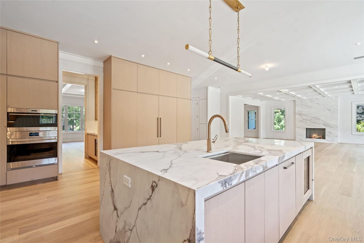 Fireplace, Interior, Kitchen, Marble Walls, Pendant Lights, Recessed Lighting, Stainless Steel Appliances, Wood Texture Flooring