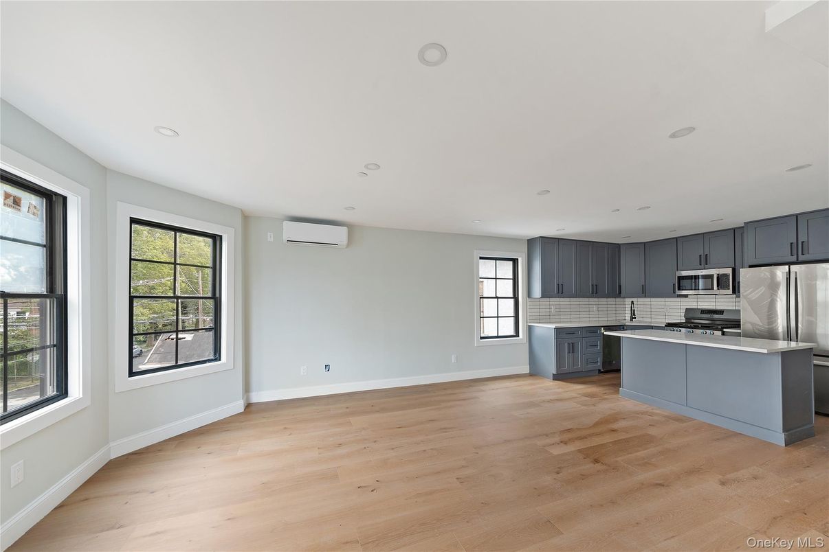 Empty room, Interior, Kitchen, Recessed Lighting, Stainless Steel Appliances, Wood Texture Flooring