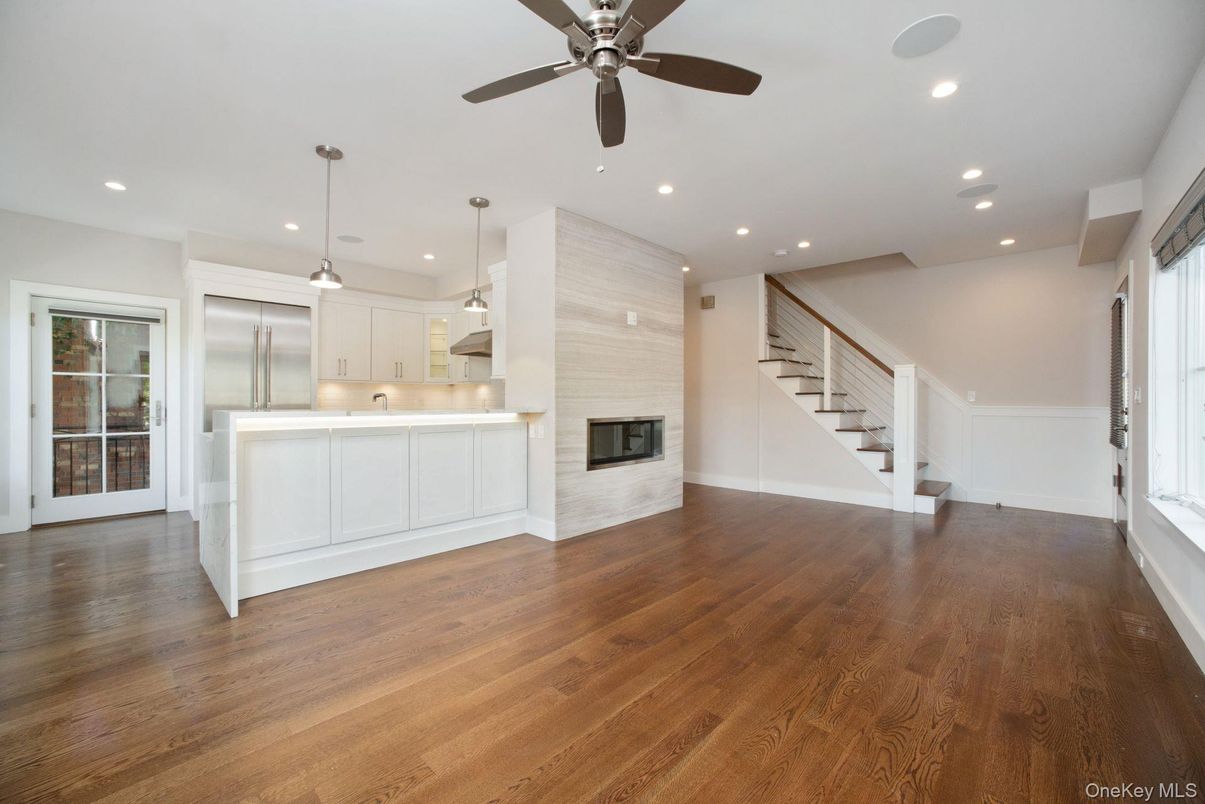 Empty room, Fireplace, Interior, Kitchen, Pendant Lights, Recessed Lighting, Stainless Steel Appliances, Wood Texture Flooring