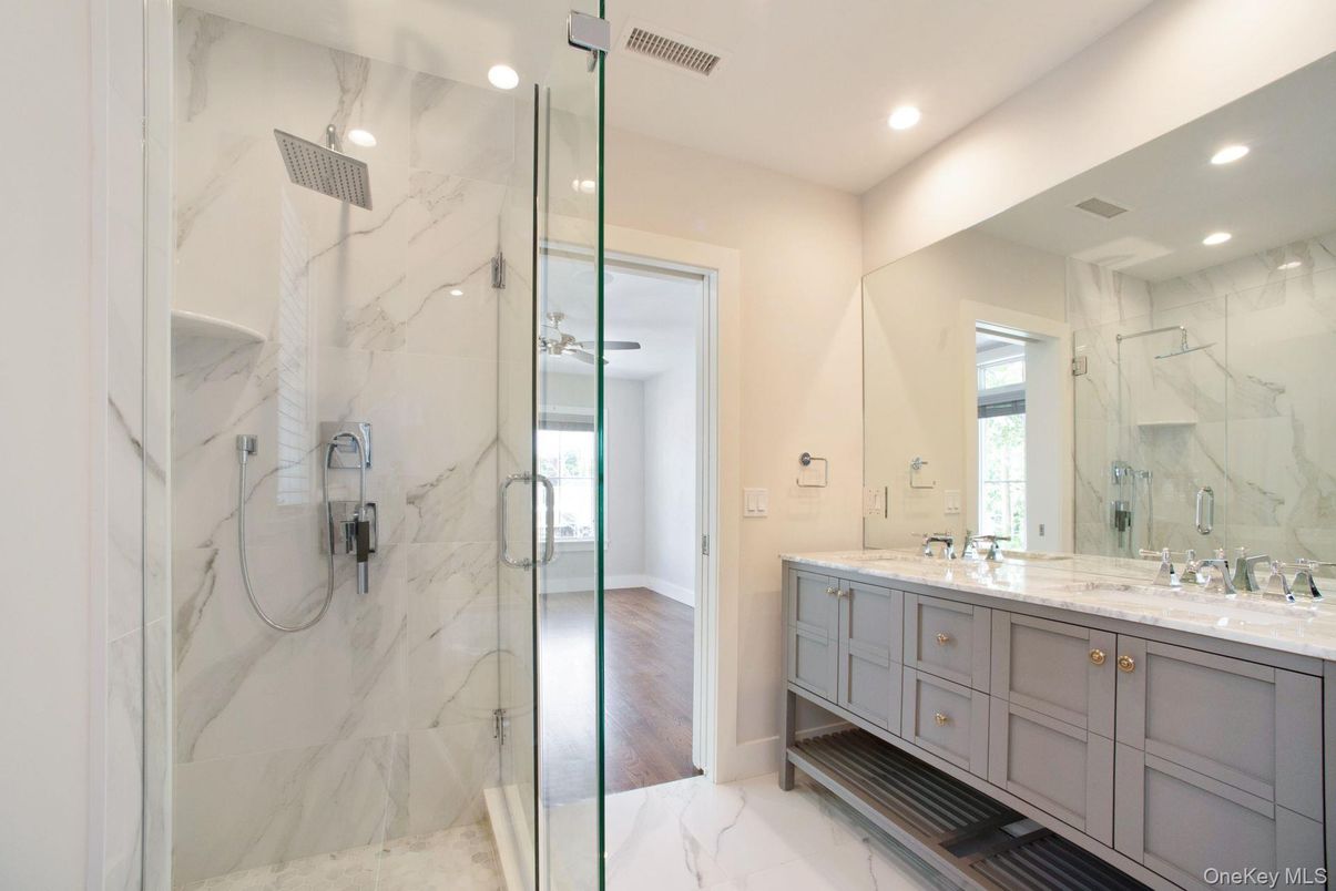 Bathroom, Dual Sink Vanities, Glass Shower, Interior, Marble, Marble Walls, Recessed Lighting, Wood Texture Flooring