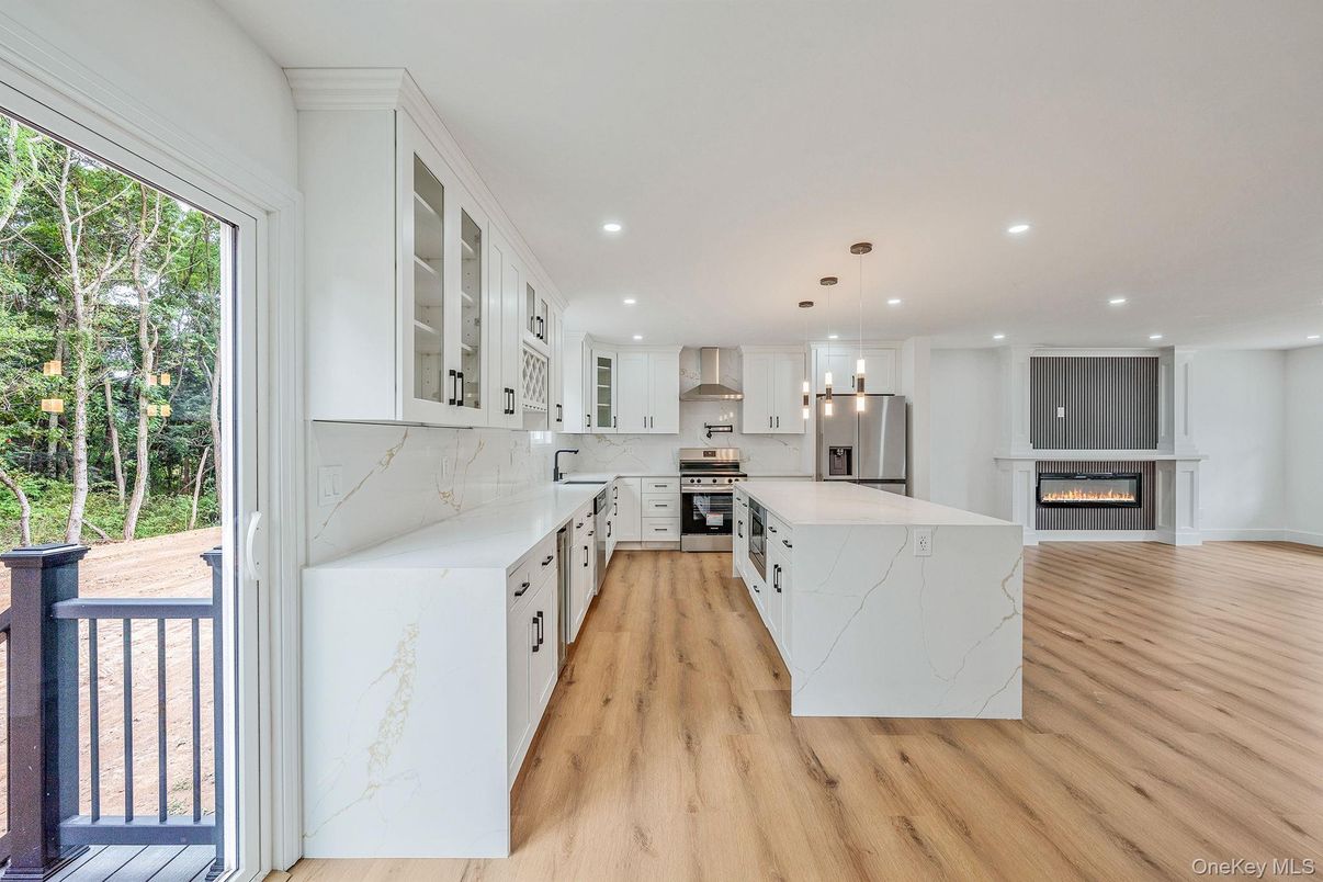 Fireplace, Interior, Kitchen, Marble Walls, Pendant Lights, Recessed Lighting, Stainless Steel Appliances, Wood Texture Flooring