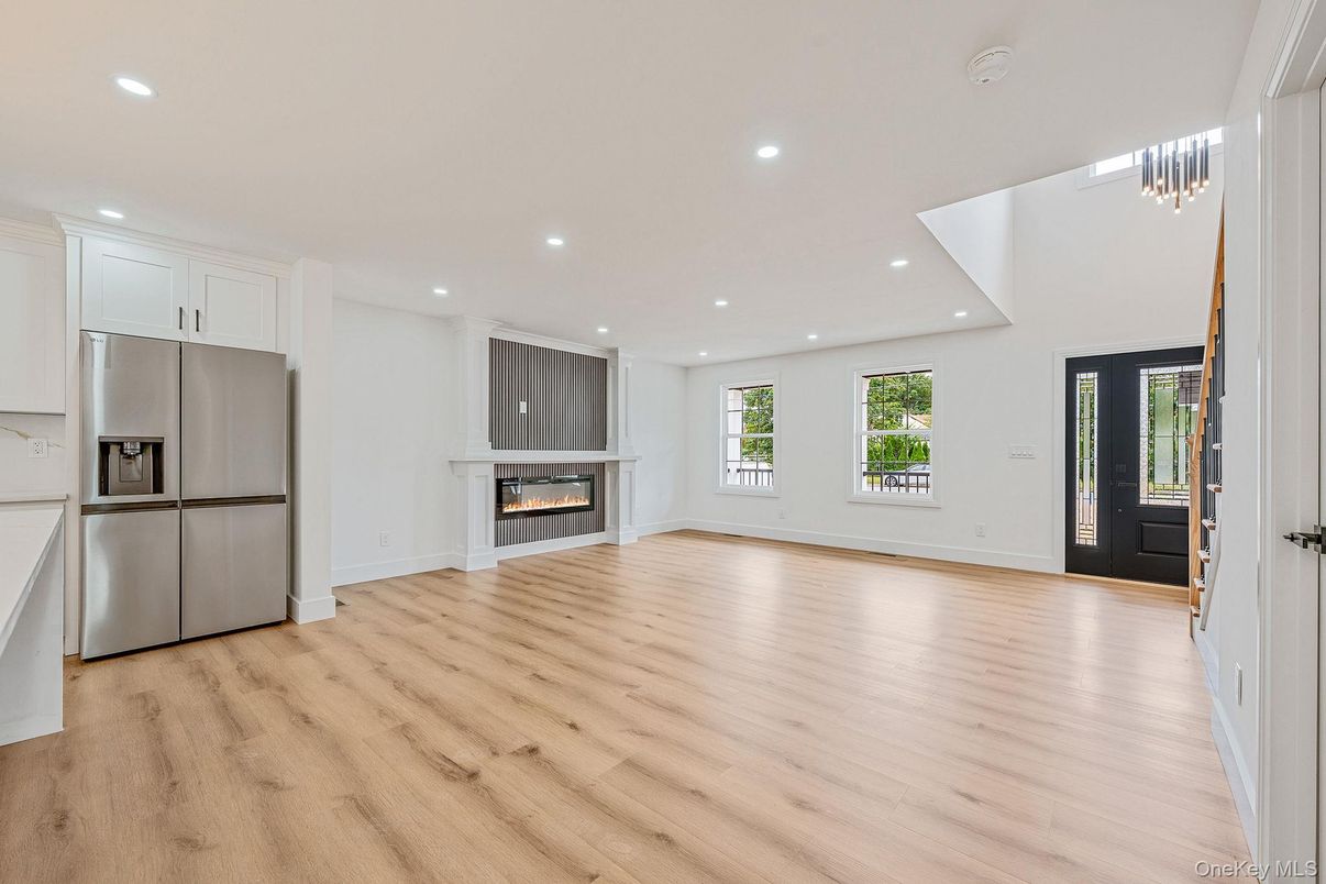 Empty room, Fireplace, Interior, Kitchen, Pendant Lights, Recessed Lighting, Stainless Steel Appliances, Wood Texture Flooring
