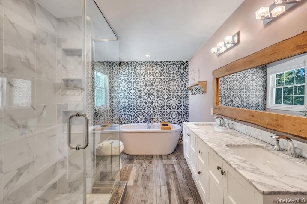 Bathroom, Dual Sink Vanities, Free Standing Baths, Glass Shower, Interior, Marble Walls, Recessed Lighting, Wood Texture Flooring