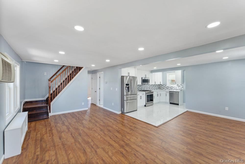 Empty room, Interior, Kitchen, Recessed Lighting, Stainless Steel Appliances, Wood Texture Flooring