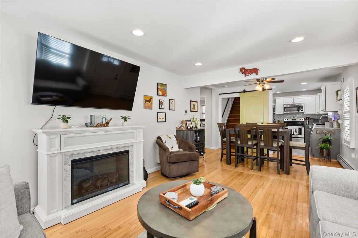 Dining room, Fireplace, Interior, Kitchen, Recessed Lighting, Stainless Steel Appliances, Wood Texture Flooring
