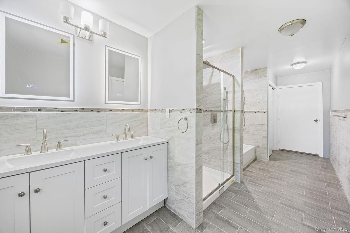 Bathroom, Dual Sink Vanities, Glass Shower, Interior, Marble Walls, Wood Texture Flooring