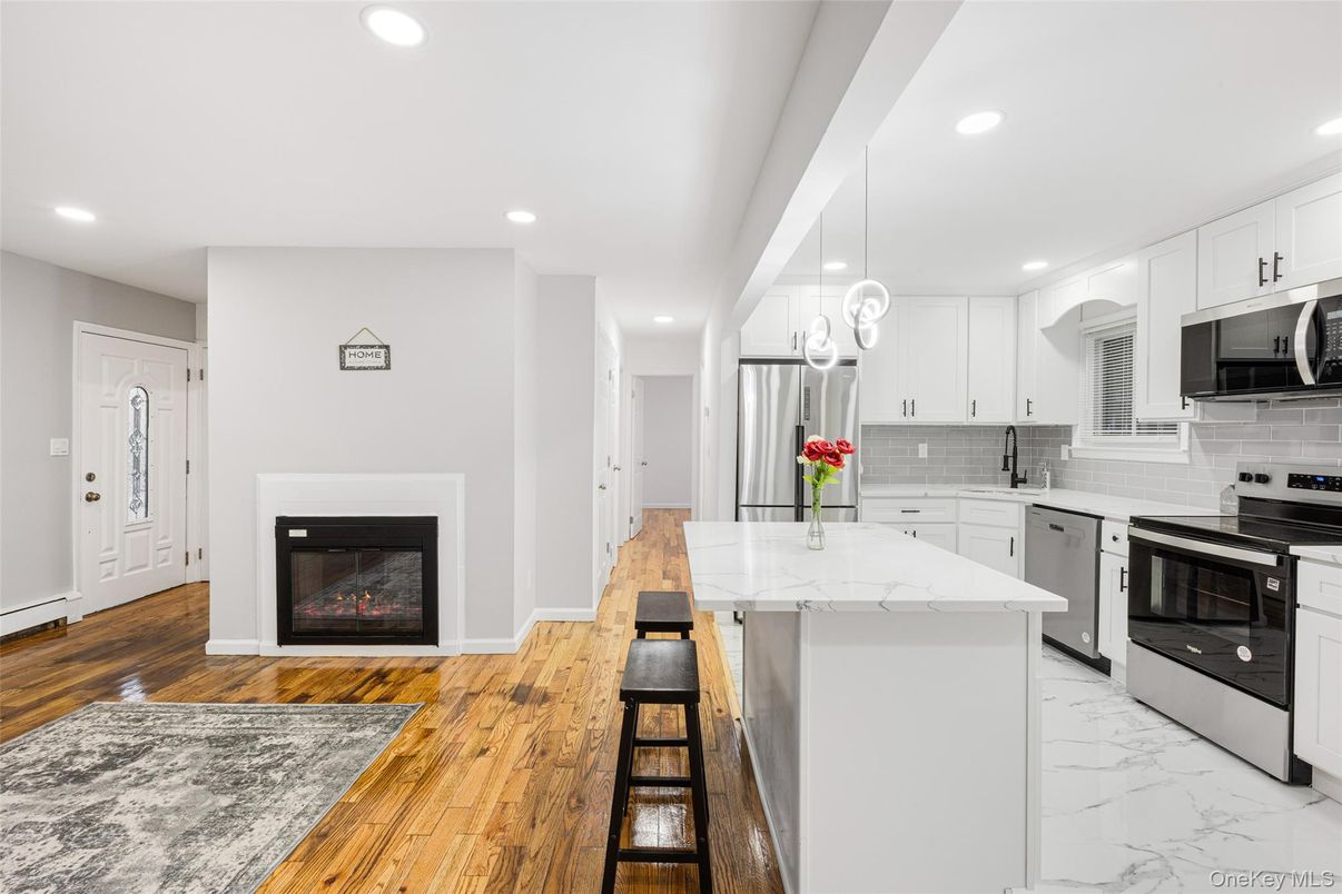 Fireplace, Interior, Kitchen, Marble, Pendant Lights, Recessed Lighting, Stainless Steel Appliances, Wood Texture Flooring