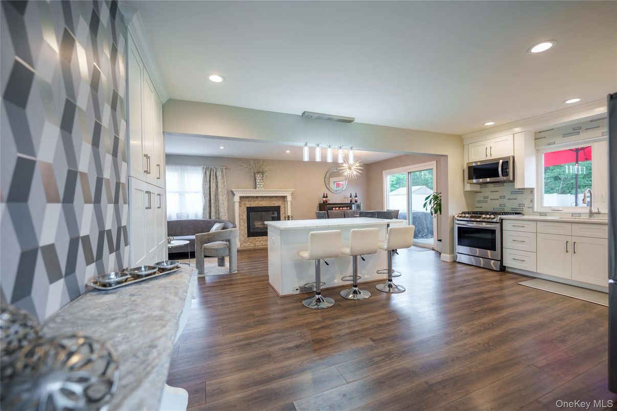 Chandelier, Dining room, Fireplace, Interior, Kitchen, Living room, Pendant Lights, Recessed Lighting, Stainless Steel Appliances, Wood Texture Flooring