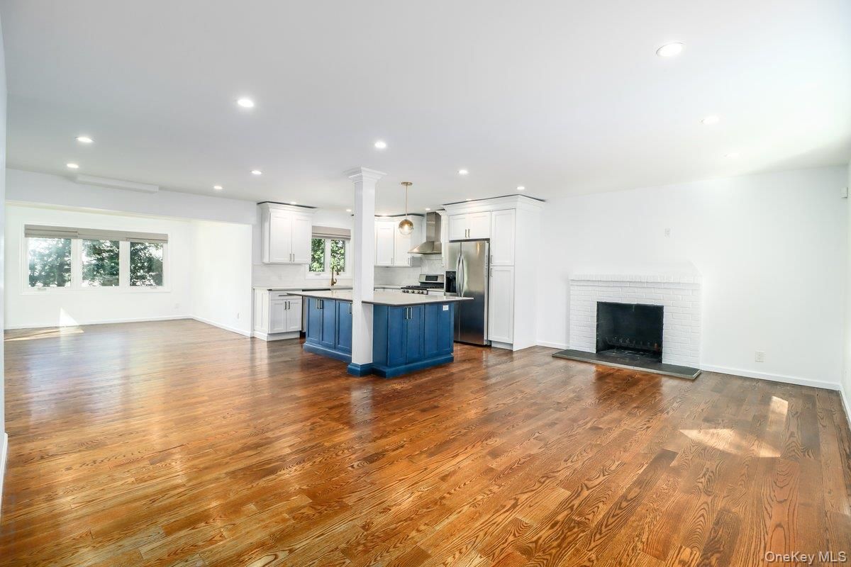 Empty room, Fireplace, Interior, Kitchen, Pendant Lights, Recessed Lighting, Stainless Steel Appliances, Wood Texture Flooring