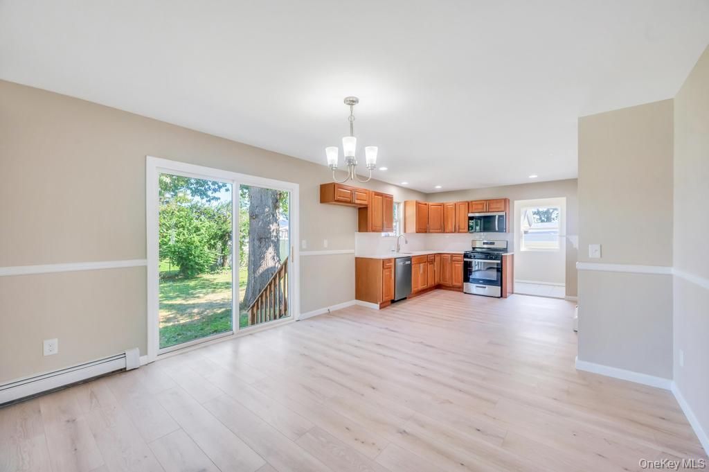 Chandelier, Empty room, Interior, Kitchen, Pendant Lights, Recessed Lighting, Stainless Steel Appliances, Wood Texture Flooring