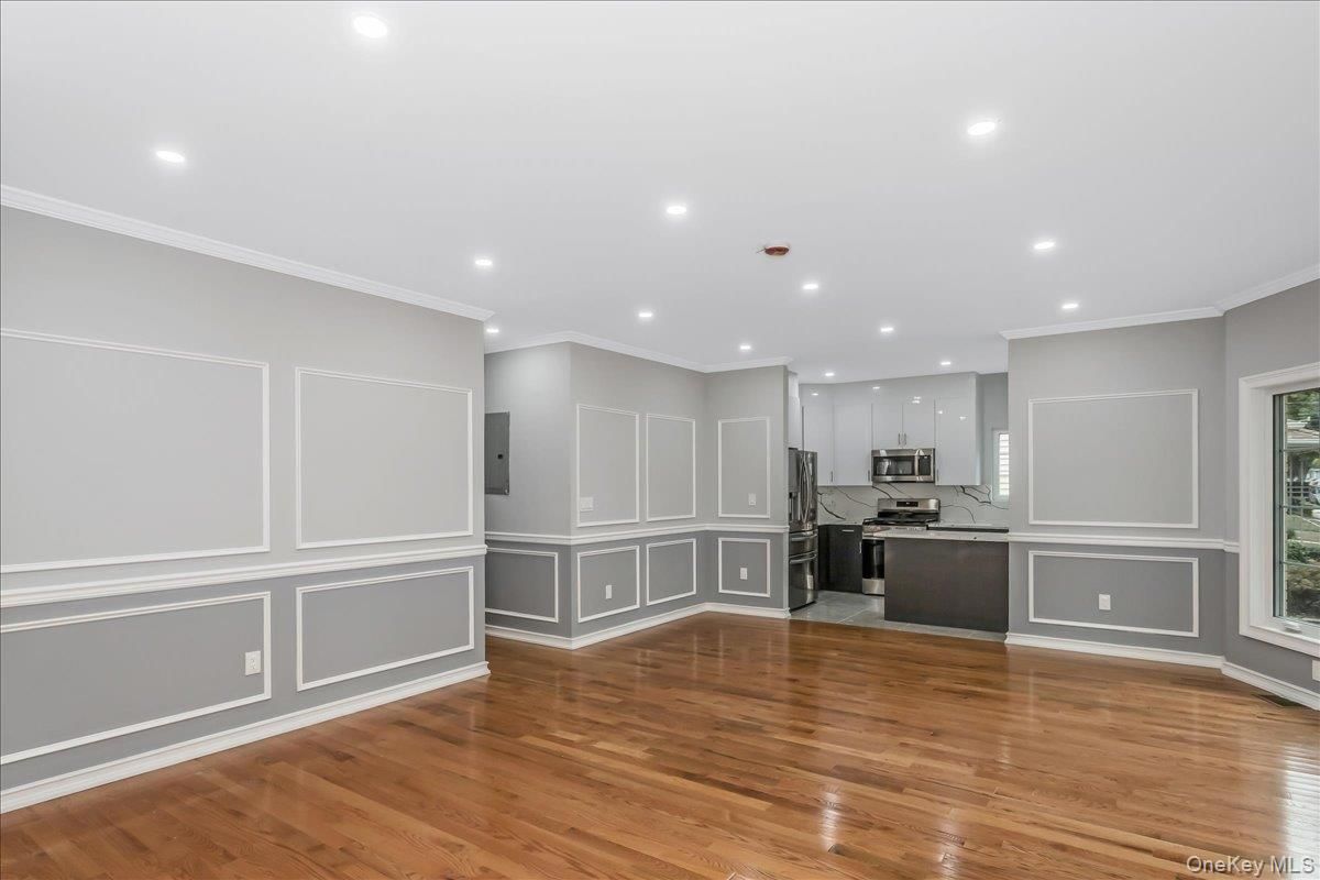 Empty room, Interior, Kitchen, Recessed Lighting, Stainless Steel Appliances, Wood Texture Flooring