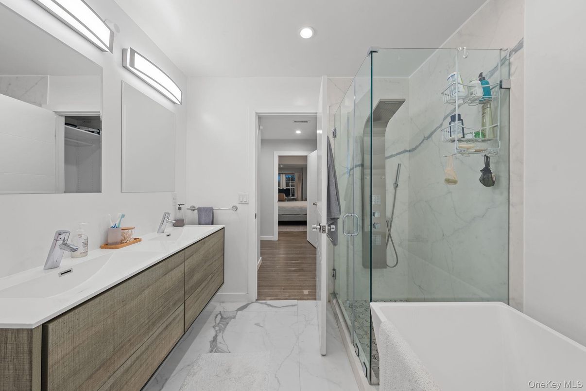 Bathroom, Dual Sink Vanities, Glass Shower, Interior, Marble, Marble Walls, Recessed Lighting, Wood Texture Flooring
