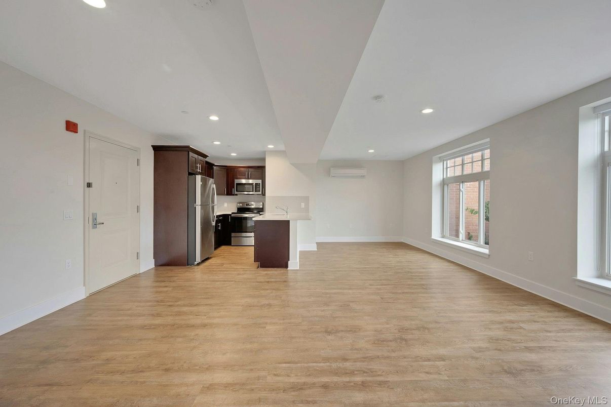 Empty room, Interior, Kitchen, Recessed Lighting, Stainless Steel Appliances, Wood Texture Flooring