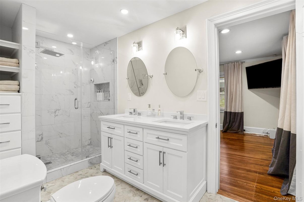 Bathroom, Dual Sink Vanities, Glass Shower, Interior, Marble, Marble Walls, Recessed Lighting, Wood Texture Flooring