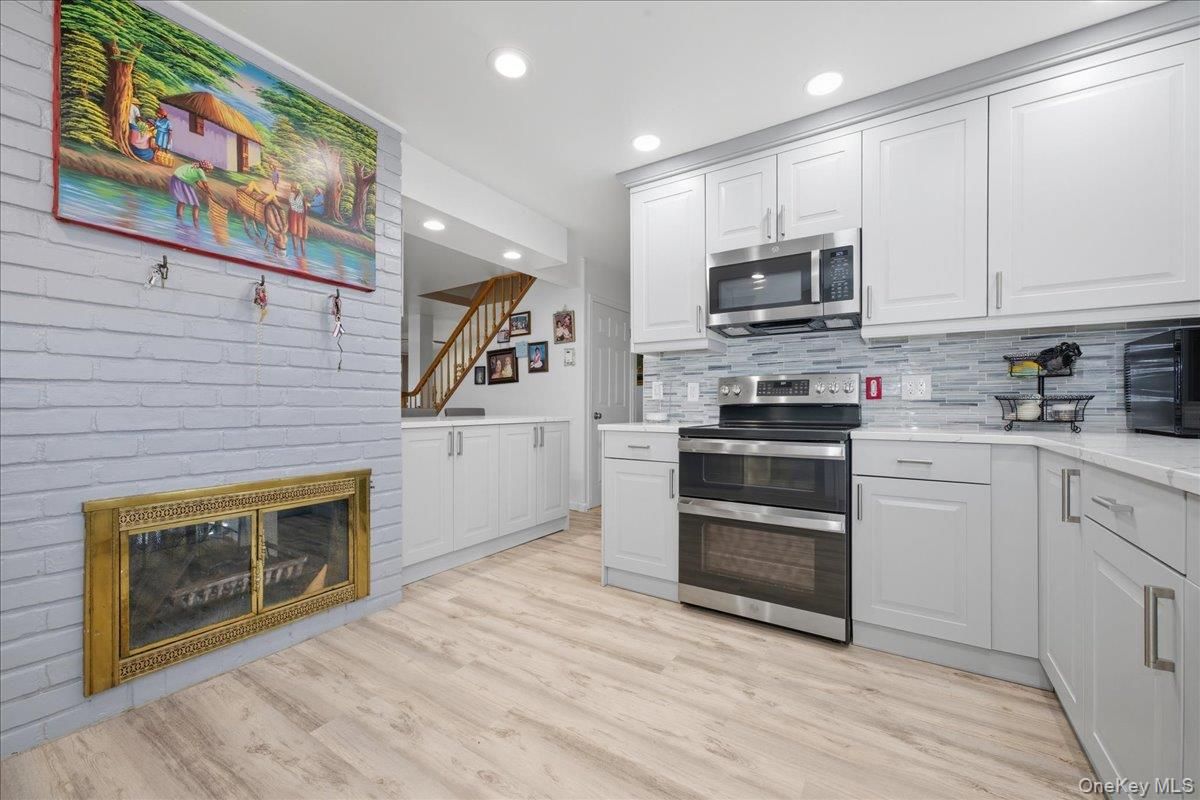 Fireplace, Interior, Kitchen, Recessed Lighting, Stainless Steel Appliances, Wood Texture Flooring
