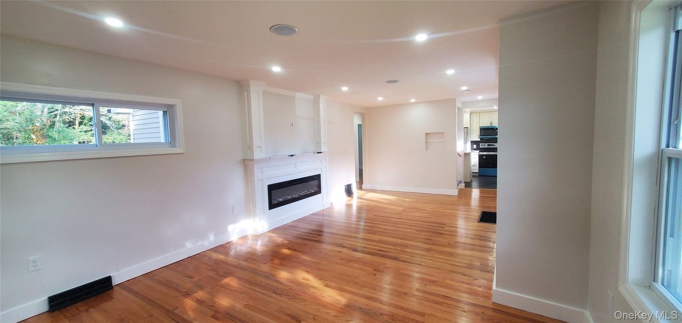 Empty room, Fireplace, Interior, Kitchen, Recessed Lighting, Stainless Steel Appliances, Wood Texture Flooring