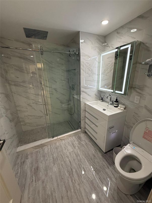 Bathroom, Dual Sink Vanities, Glass Shower, Interior, Marble Walls, Recessed Lighting, Wood Texture Flooring