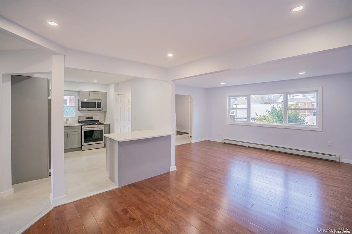 Empty room, Interior, Kitchen, Recessed Lighting, Stainless Steel Appliances, Wood Texture Flooring