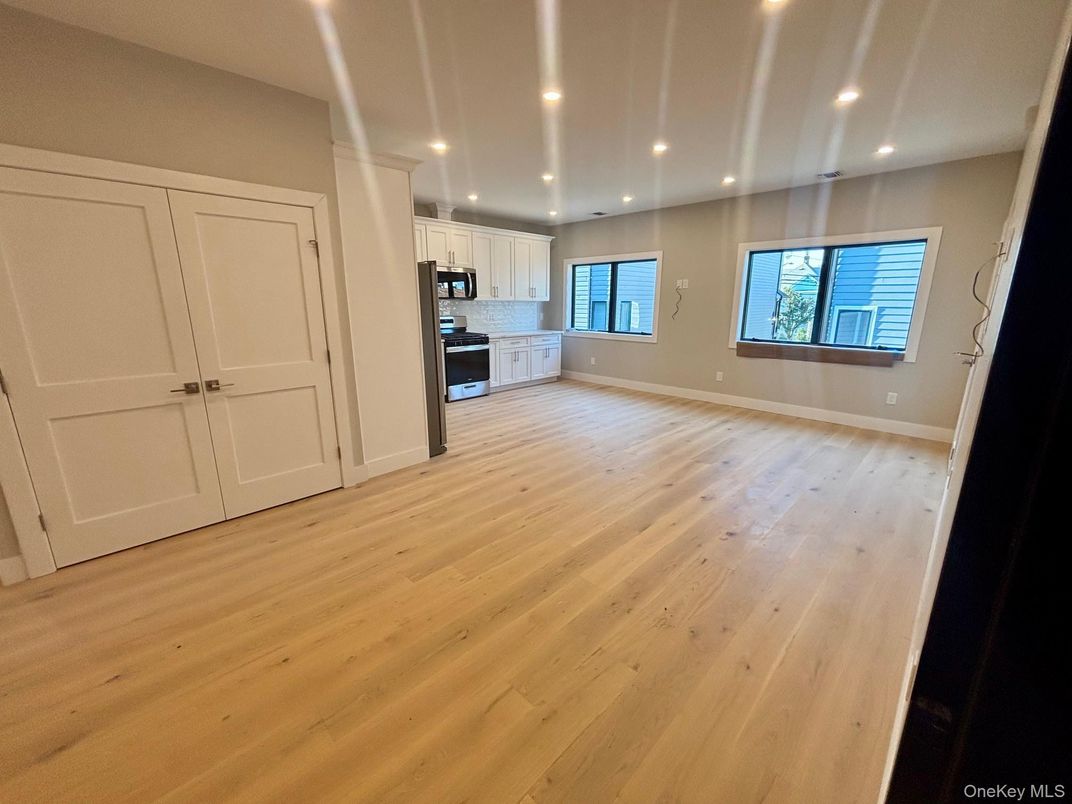 Empty room, Interior, Kitchen, Recessed Lighting, Stainless Steel Appliances, Wood Texture Flooring