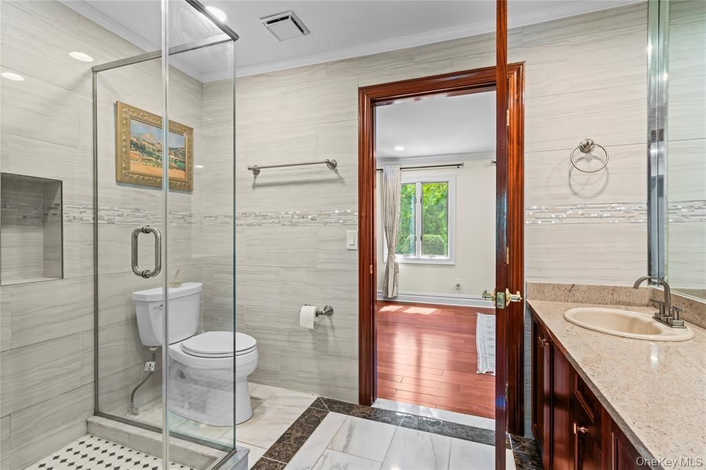 Bathroom, Dual Sink Vanities, Glass Shower, Interior, Marble, Recessed Lighting, Wood Texture Flooring
