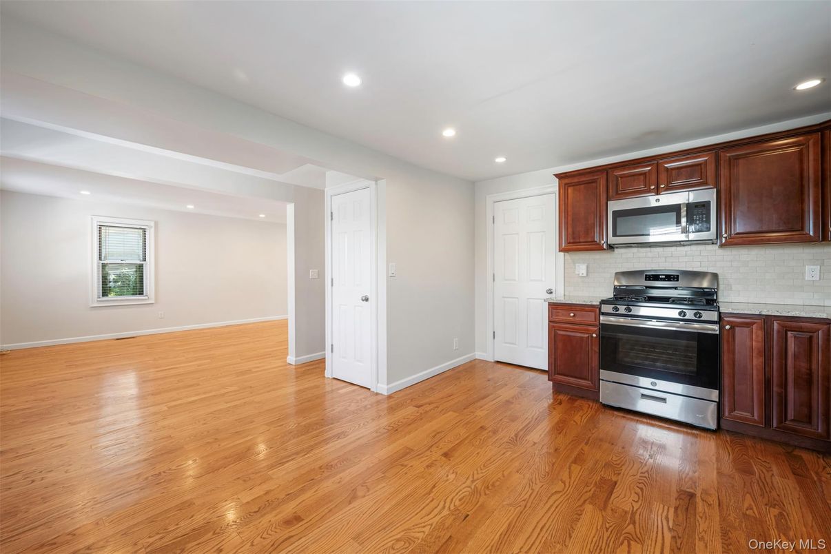Empty room, Interior, Kitchen, Recessed Lighting, Stainless Steel Appliances, Wood Texture Flooring