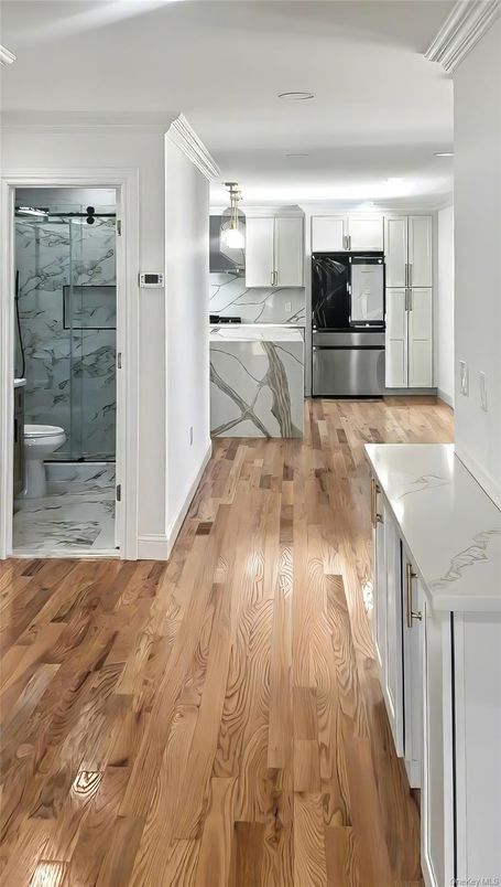 Interior, Kitchen, Marble Walls, Recessed Lighting, Stainless Steel Appliances, Wood Texture Flooring