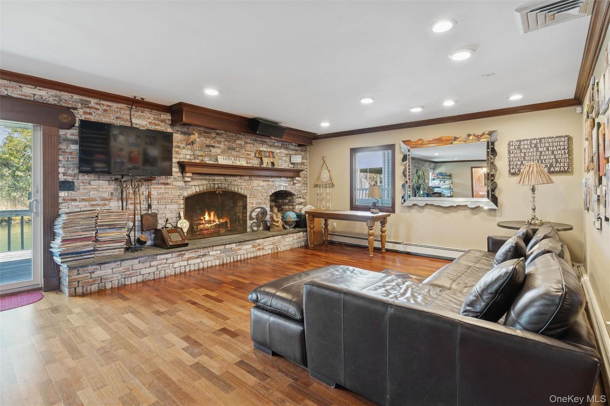 Fireplace, Game Room, Interior, Living room, Recessed Lighting, Stone Walls, Wood Texture Flooring