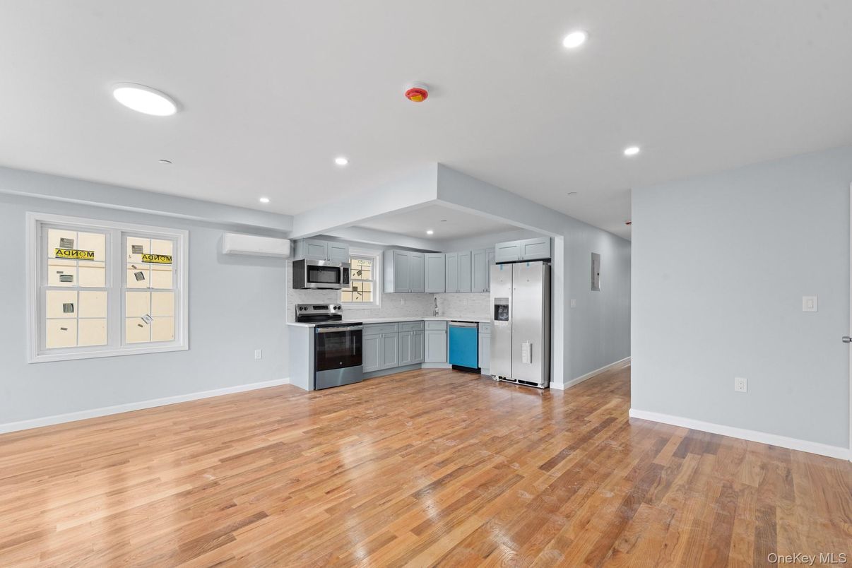 Empty room, Interior, Kitchen, Recessed Lighting, Stainless Steel Appliances, Wood Texture Flooring