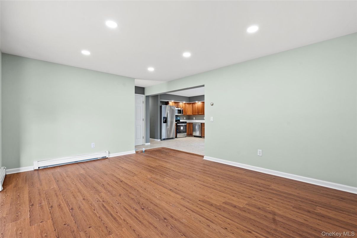 Empty room, Interior, Kitchen, Recessed Lighting, Stainless Steel Appliances, Wood Texture Flooring