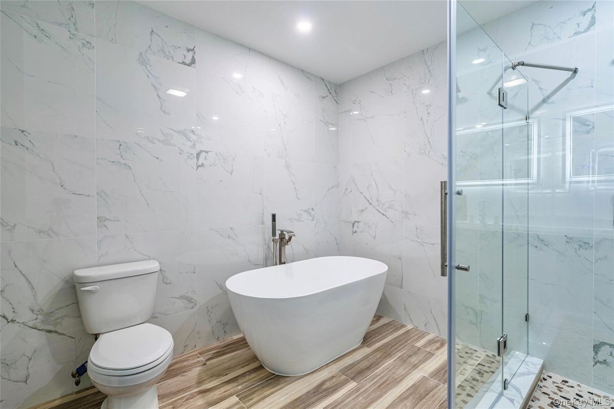 Bathroom, Free Standing Baths, Glass Shower, Interior, Marble Walls, Recessed Lighting, Wood Texture Flooring