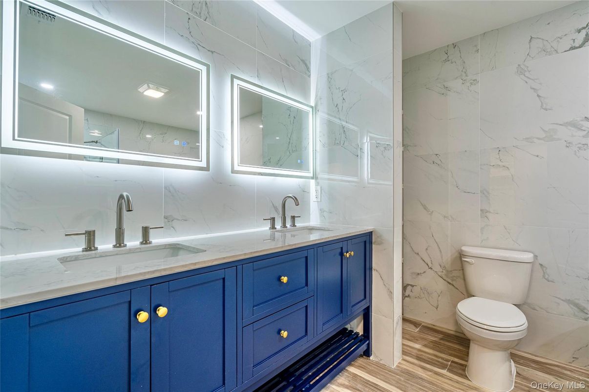 Bathroom, Dual Sink Vanities, Interior, Marble Walls, Recessed Lighting, Wood Texture Flooring
