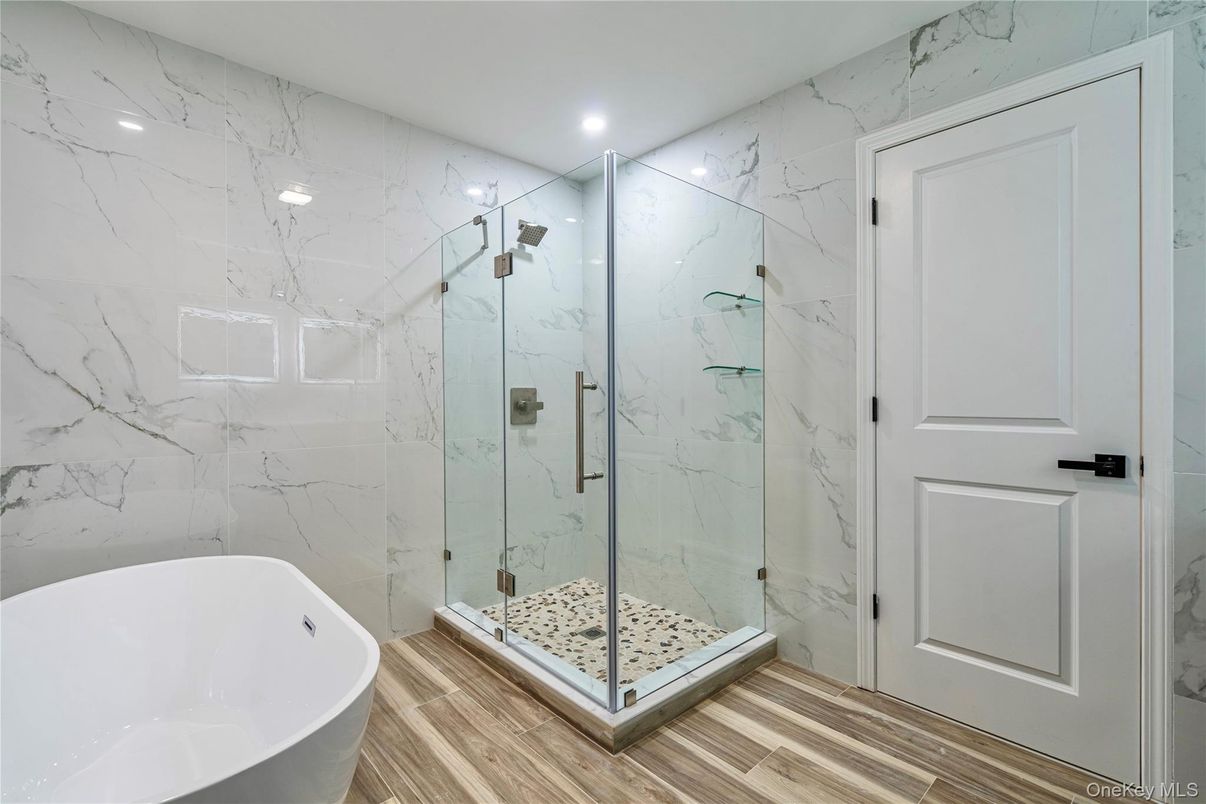 Bathroom, Free Standing Baths, Glass Shower, Interior, Marble Walls, Recessed Lighting, Wood Texture Flooring