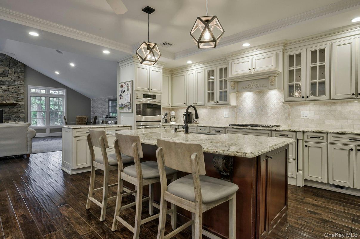 Fireplace, Interior, Kitchen, Living room, Pendant Lights, Recessed Lighting, Stainless Steel Appliances, Stone Walls, Wood Texture Flooring