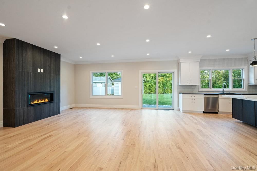 Empty room, Fireplace, Interior, Kitchen, Pendant Lights, Recessed Lighting, Stainless Steel Appliances, Wood Texture Flooring