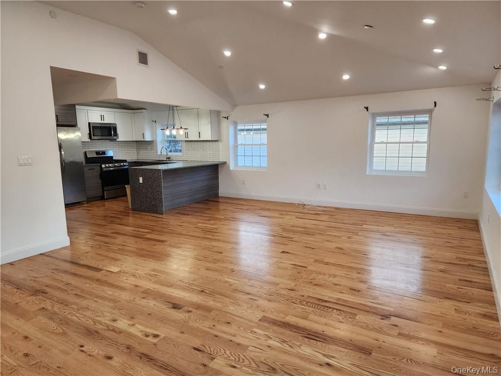 Empty room, Interior, Kitchen, Recessed Lighting, Stainless Steel Appliances, Wood Texture Flooring