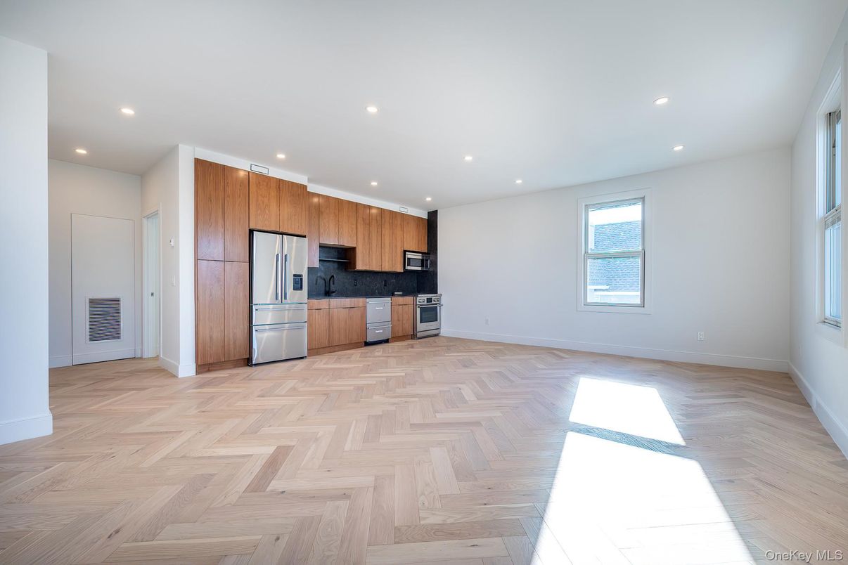 Empty room, Interior, Kitchen, Recessed Lighting, Stainless Steel Appliances, Wood Texture Flooring
