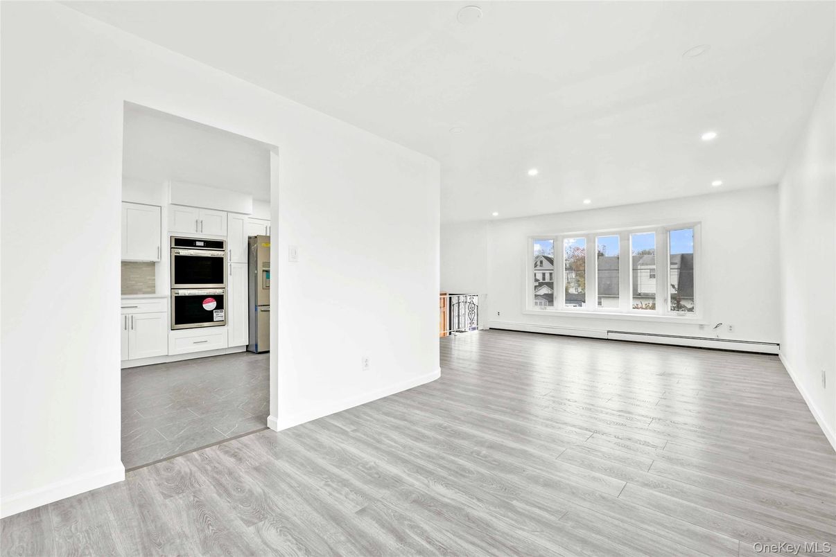 Empty room, Interior, Kitchen, Recessed Lighting, Stainless Steel Appliances, Wood Texture Flooring
