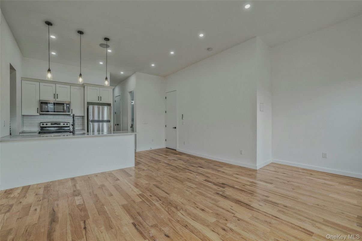 Empty room, Interior, Kitchen, Pendant Lights, Recessed Lighting, Stainless Steel Appliances, Wood Texture Flooring